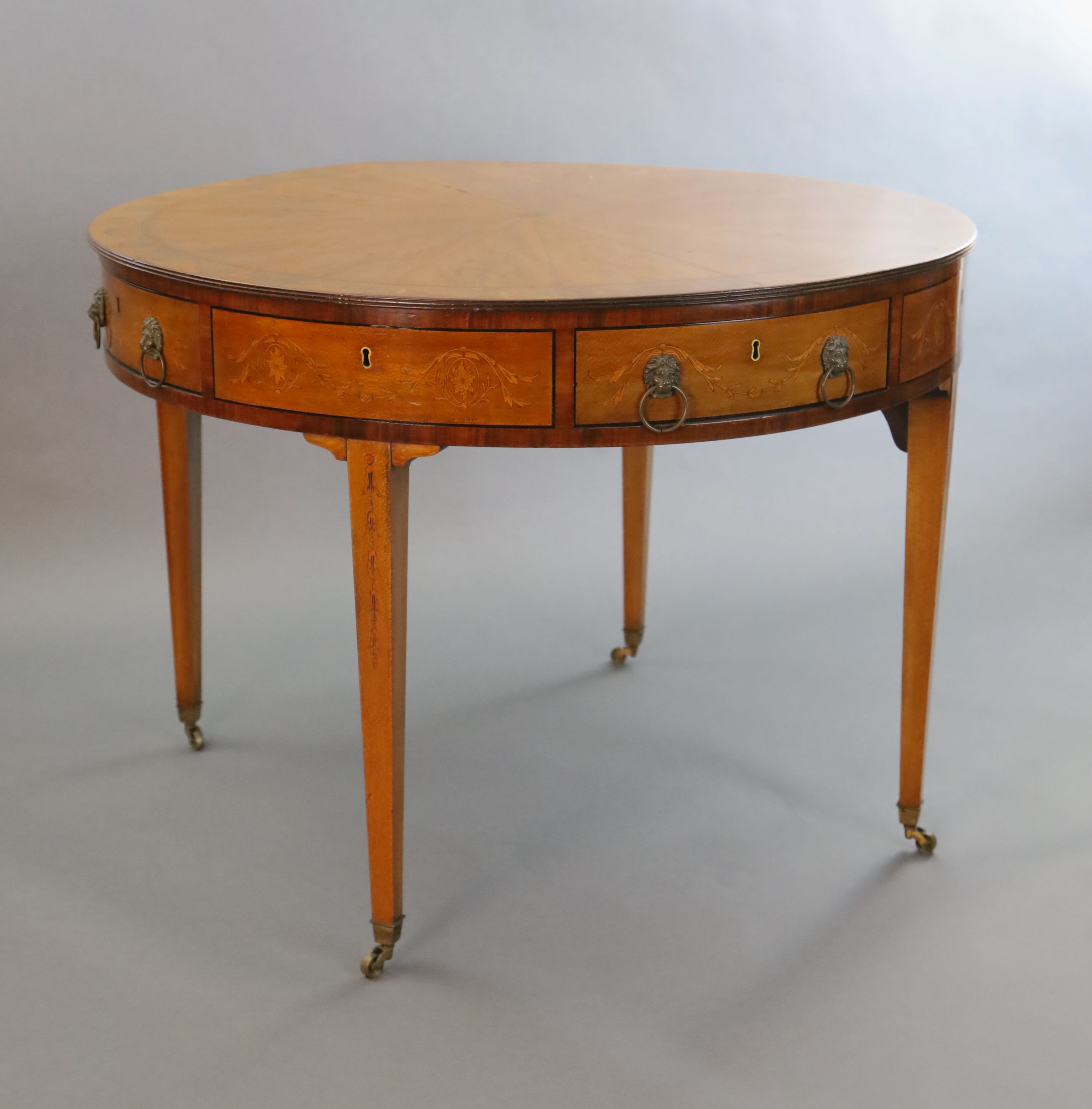 An Edwardian marquetry inlaid satinwood drum top library table, Diam. 3ft 5.5in H.2ft 5.5in.